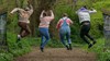 People jumping on a woodland path